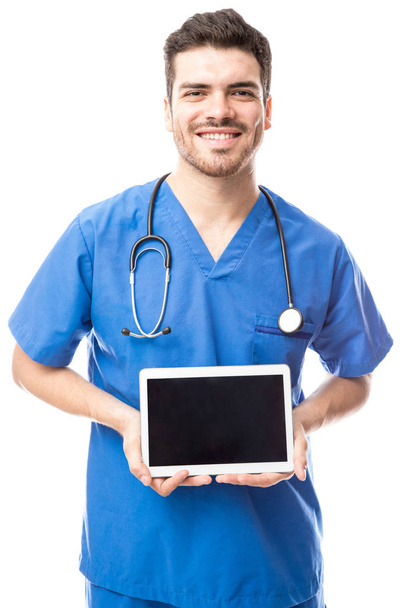 young doctor showing screen of tablet - Fotó, kép