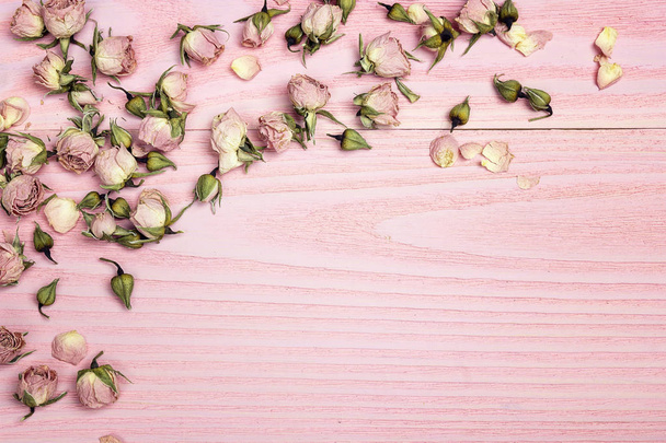 Border of rose flowers on the pink wooden background with copy s - Photo, image