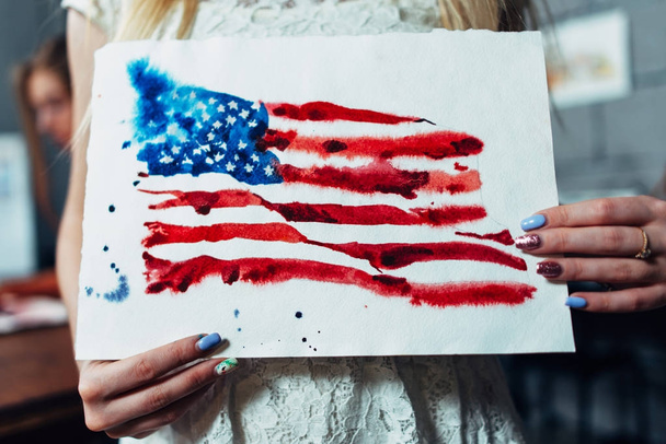 Close-Up Nézd női kéz, gazdaság egy papírlapot a kézi-Attila, akvarell illusztrációja az Egyesült Államok zászlaja - Fotó, kép