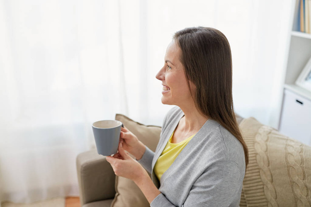 happy woman drinking tea or coffee at home - Foto, Imagem