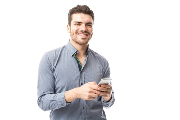 pohledný mladý muž kontrola smartphone - Fotografie, Obrázek