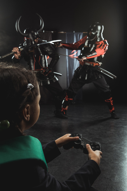schoolchild playing samurai fighting with gamepad in real life - Photo, Image
