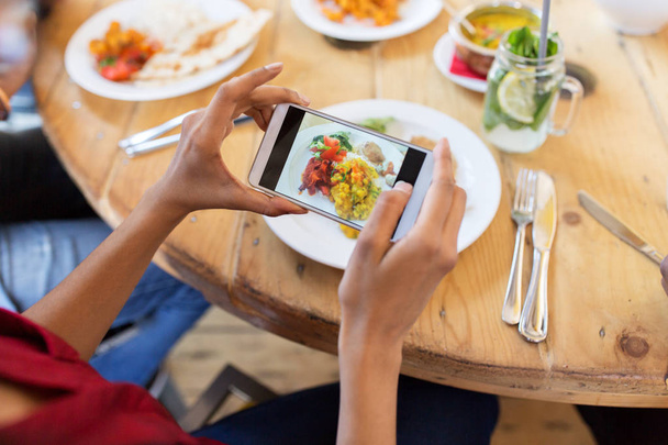hands with smartphone picturing food at restaurant - Fotografie, Obrázek