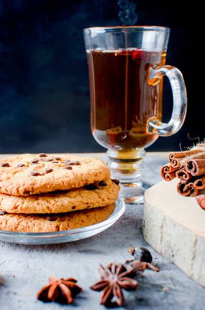 cookies with chocolate drops, сup of  tea, cinnamon, anise on d - 写真・画像