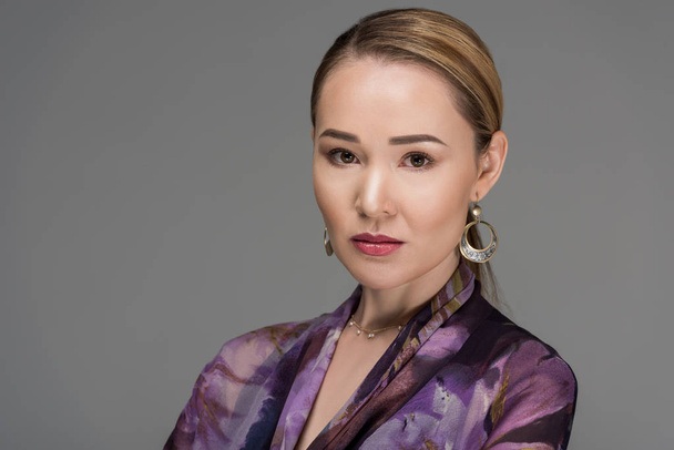 Close-up portret van mooie vrouw van Kazachs kijken camera geïsoleerd op grijs     - Foto, afbeelding