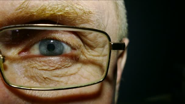 Un occhio del vecchio che indossa occhiali con i capillari rossi. Macro
 - Filmati, video
