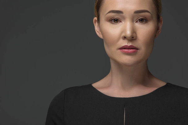 portrait of beautiful kazakh woman looking at camera isolated on grey  - Foto, afbeelding