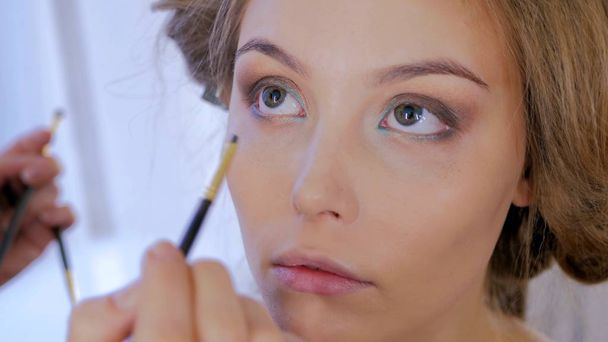 Ammattimainen meikki taiteilija soveltamalla eyeliner ympäri koko silmän mallin
 - Valokuva, kuva