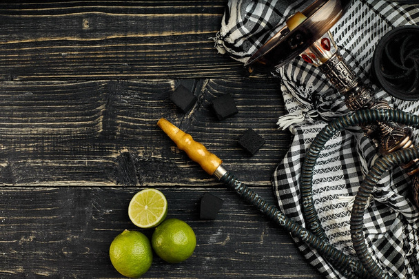 Arabic hookah with a tobacco flavor of a mixture of lime. Top view of a dark wooden background - Fotoğraf, Görsel