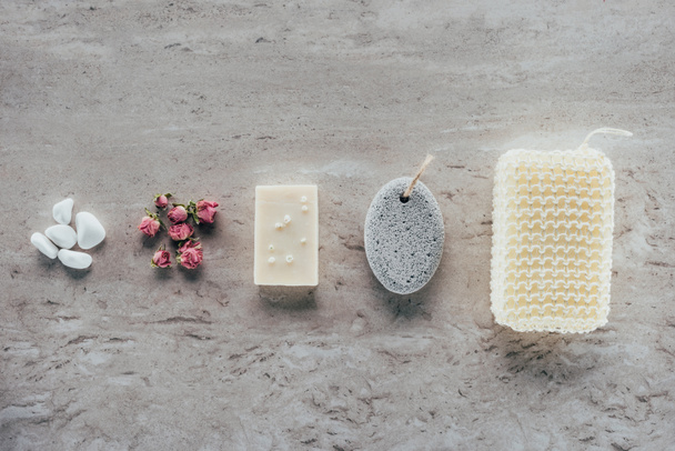vista superior de piedras, rosas secas, jabón natural, piedra pómez y esponja de baño para spa en superficie de mármol
 - Foto, imagen