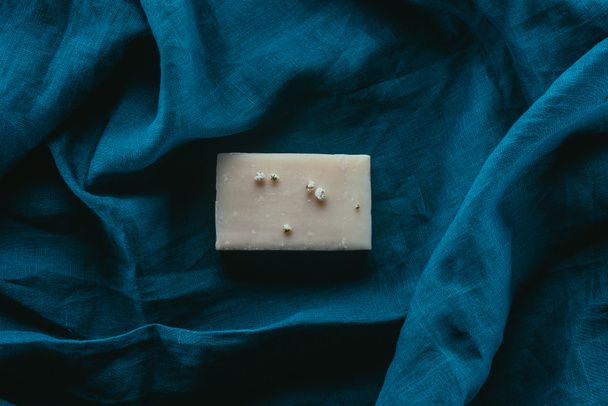 pohled shora na přírodní domácí mýdlo na tmavě modré povlečení - Fotografie, Obrázek