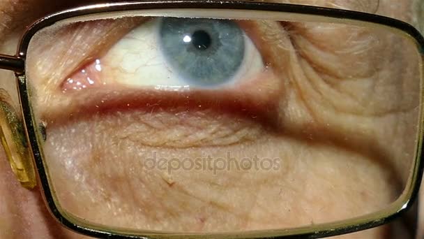 Μάτι των παλιών άνδρα που φοράει γυαλιά με κόκκινο τριχοειδή αγγεία. Μακροεντολή - Πλάνα, βίντεο