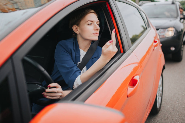 Женщина чувствует стресс на дороге. Показывает факт в окне. Большие пробки. Деловая женщина опаздывает на работу
 - Фото, изображение