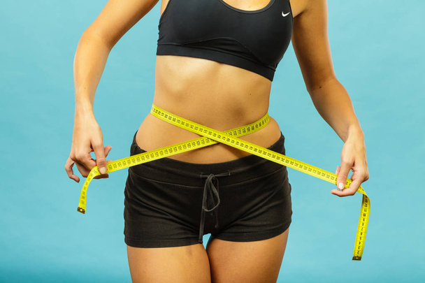 Fitness girl measuring her waistline - Foto, Imagem