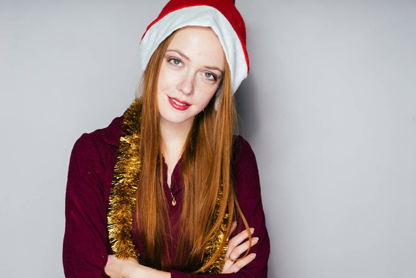 beautiful red-haired girl in a hood like Santa Claus celebrates the new year 2018 - Фото, изображение