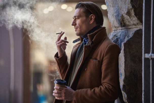 Thoughtful male firing tobacco on street - Zdjęcie, obraz