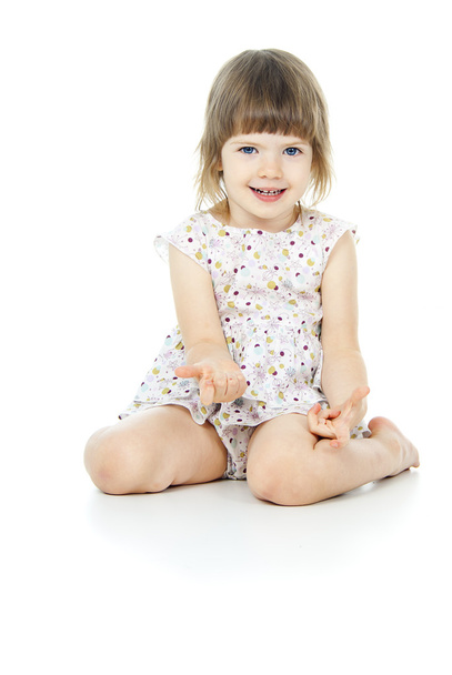 sits a beautiful little girl in a dress - Foto, Bild