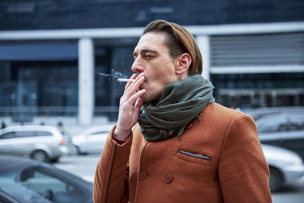 Calm male inhaling tobacco outside - Foto, imagen