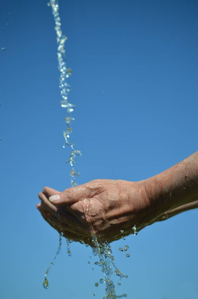 agua que fluye del cielo en las manos abiertas con ventosas
 - Foto, imagen