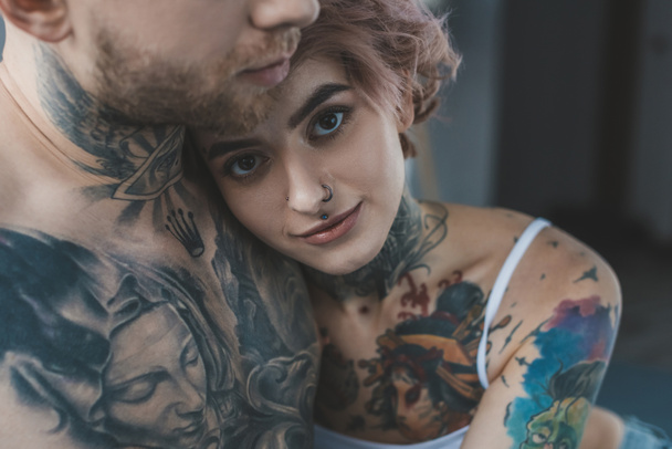 молода татуйована дівчина обіймає свого хлопця
  - Фото, зображення