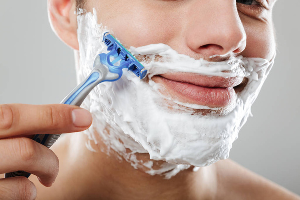 Крупный план портрета молодого человека с пеной для бритья
 - Фото, изображение