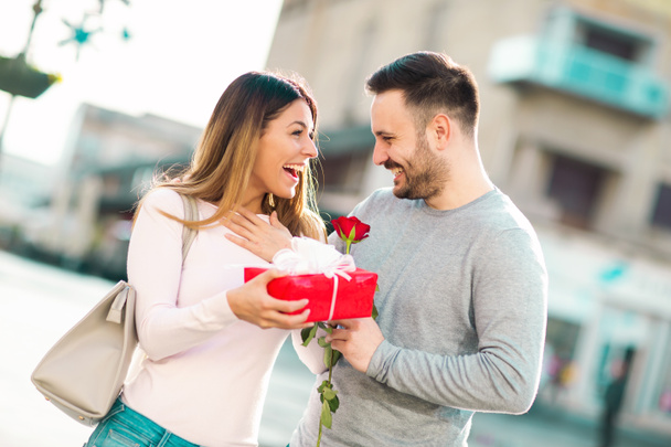 Man surprises woman with a gift in the city - Photo, Image