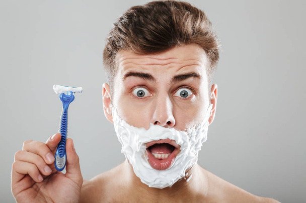 Close up portrait of an excited man with shaving foam - 写真・画像