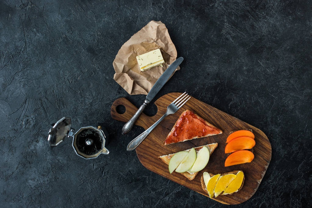 flat lay with tasty healthy breakfast on wooden cutting board on dark tabletop - Φωτογραφία, εικόνα
