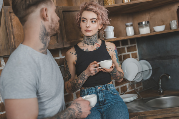 joven pareja tatuada bebiendo café juntos por la mañana
 - Foto, Imagen