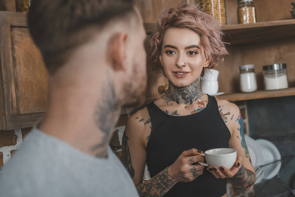 hermosa pareja tatuada beber café juntos por la mañana
 - Foto, Imagen