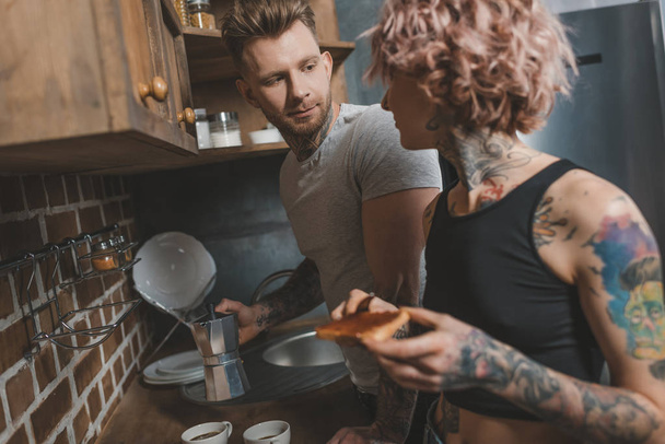 tattooed couple cooking breakfast at kitchen - Fotoğraf, Görsel