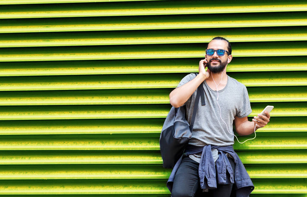 man with earphones and smartphone over wall - Foto, imagen