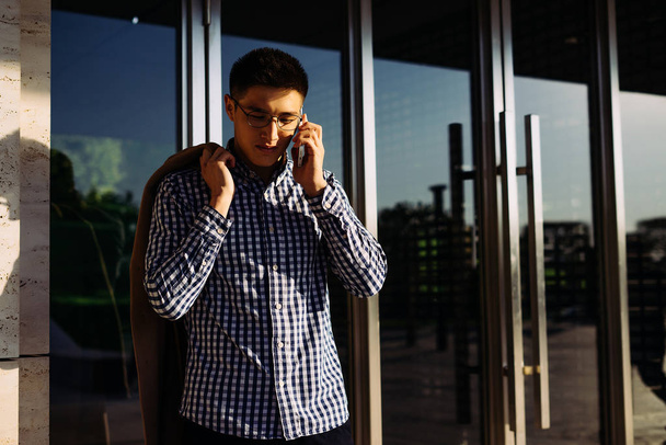 confident young Asian man wearing glasses talking on the phone - Photo, Image