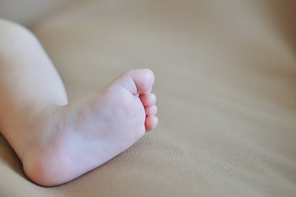 A close-up of tiny baby feet - Foto, afbeelding