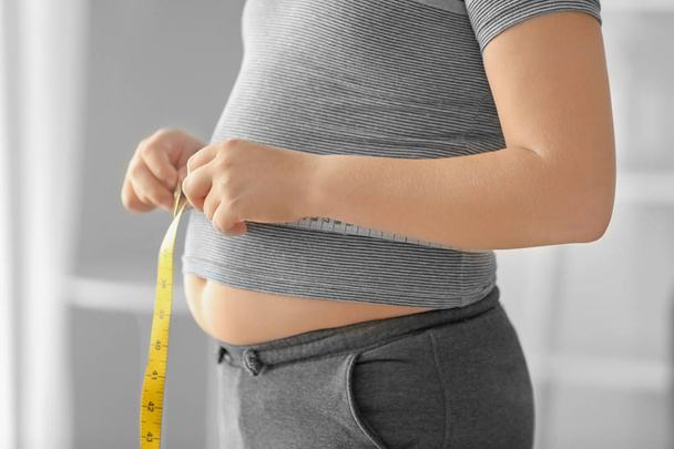 Overweight boy measuring waist   - Foto, Imagen