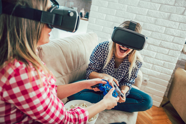 Girls hold modern devices, VR glasses and inspect, study possibilities of gadget and communicate with each other - Foto, Bild