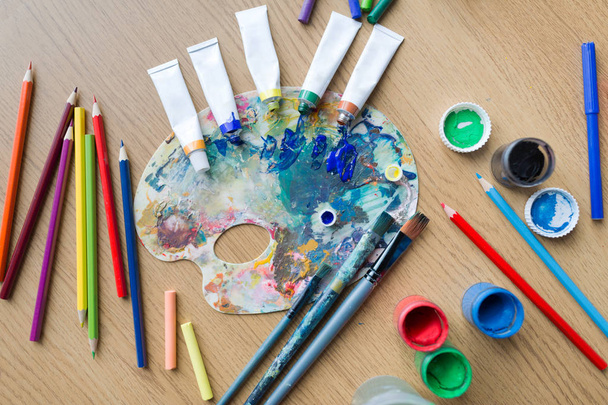 color palette, brushes and paint tubes on table - Fotó, kép