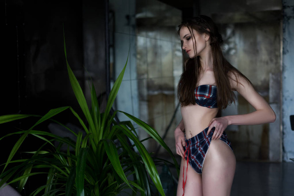 The beautiful girl wearing checkered underwear standing near gre - Valokuva, kuva
