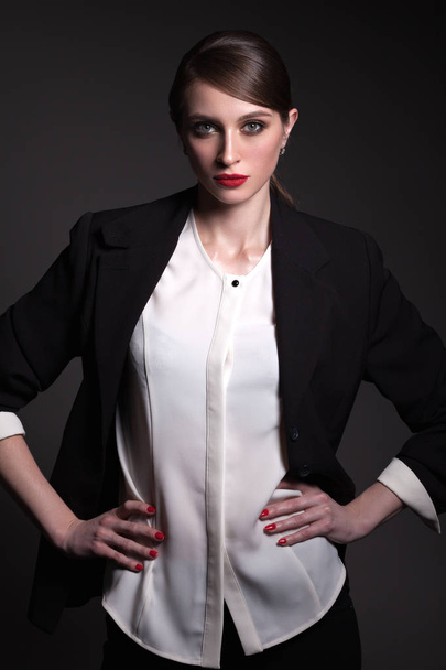A beautiful woman in a black jacket and black pants, with a crea - Foto, Bild