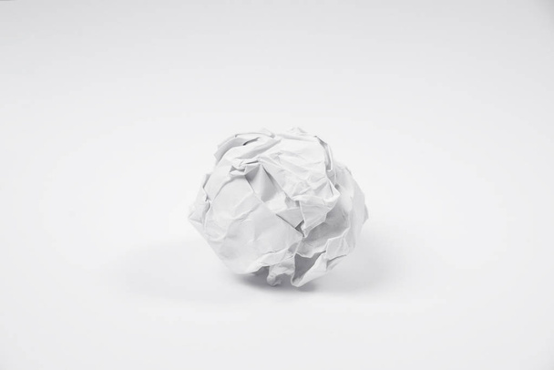 τσαλακωμένο χαρτί μπάλα σε λευκό φόντο. κεντρική ιδέα  - Φωτογραφία, εικόνα