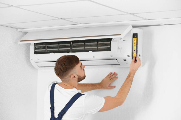 technician installing air conditioner - Foto, imagen