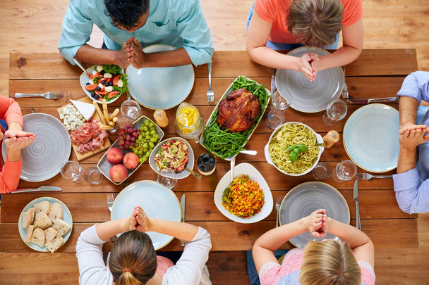 группа людей за столом молящихся перед едой
 - Фото, изображение