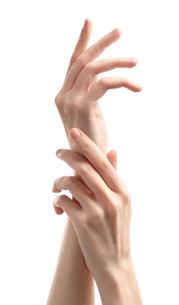Young woman touching her hand and feeling moisturizing effect of cream on white background - Foto, afbeelding