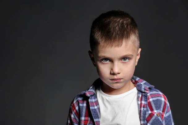 Sad little boy being bullied at school on dark background - Valokuva, kuva