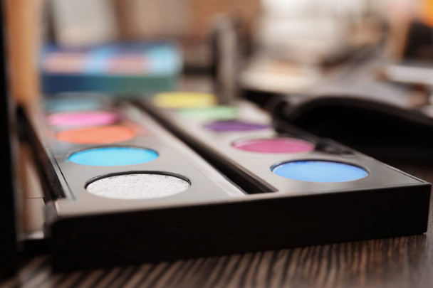 Eyeshadow palette of professional makeup artist on dressing table, closeup - Valokuva, kuva