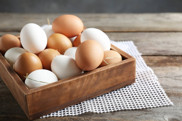 Chicken eggs in box on wooden table - Foto, Imagen