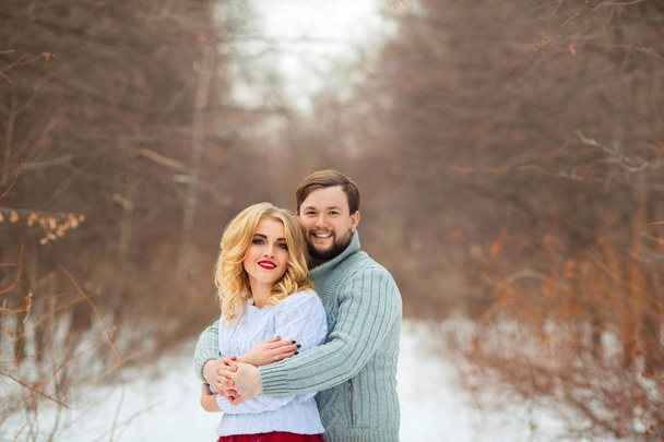 красивая молодая пара влюбленная, в легких свитерах, гуляющая в парке в холодную погоду
 - Фото, изображение
