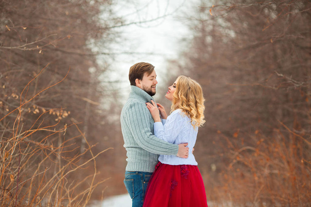 beautiful young couple in love, in light sweaters, walking in the park in cold weather - Фото, зображення