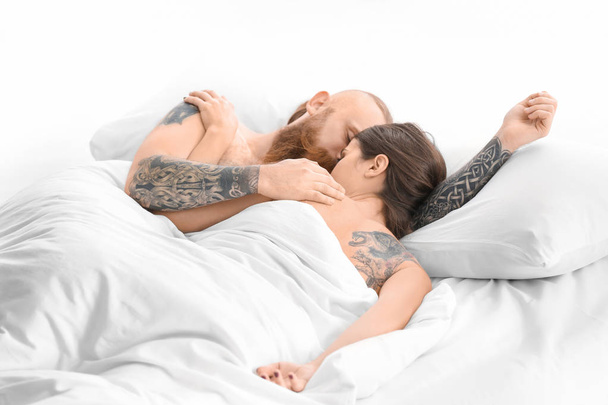 Attractive young couple with tattoos in bed at home - Foto, Imagen