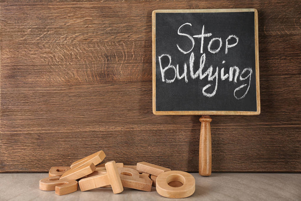 Chalkboard with text "Stop bullying" on wooden background - Foto, immagini